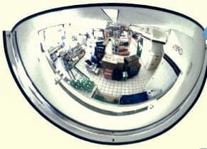 Half dome mirror mounted at a convenience store wall showing the cooler aisle and back corner
