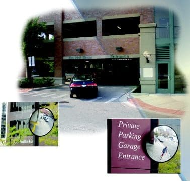 Parking garage street entrance with convex mirrors mounted at the exit lane and on the entrance sign
