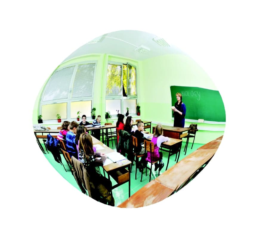 Convex mirror view of a classroom showing students at desks and a teacher at the board
