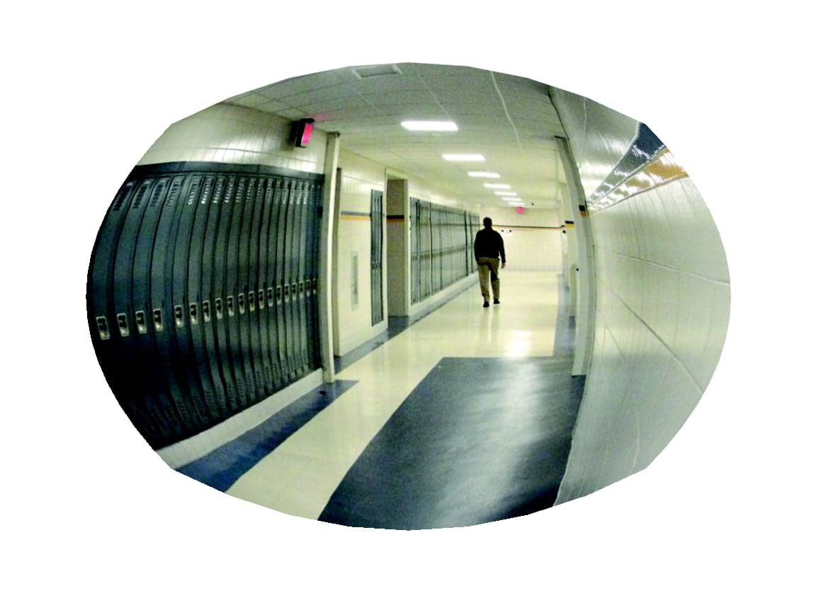 Convex mirror view down a school hallway lined with lockers, showing a person walking away from the intersection